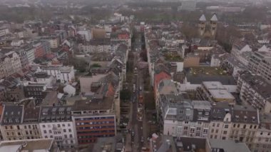 Cologne Belçika 'nın çeyrek mahallesindeki işlek bir caddenin hava görüntüsü, Almanya. İnsansız hava aracı klasik binalar ve St. Michael Kilisesi yakınlarındaki Bruesseler Platz ile çevrili arabaların üzerinden uçuyor..