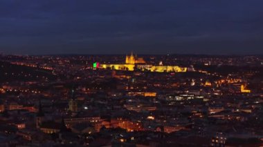 Prag 'ın büyüleyici alacakaranlık manzarası aydınlanmış kaleyi gözler önüne seriyor, şehrin olağanüstü mimarisini ve karanlık gökyüzüne karşı canlı bir ufuk çizgisi seriyor..