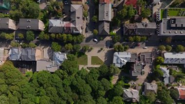 Kuş bakışı görüntüsü Kaunas, Litvanya 'nın çatılarını gösteriyor. Kamera, büyüleyici evler ve yemyeşil alanlarla dolu canlı bir mesken üzerinde sorunsuzca süzülüyor..