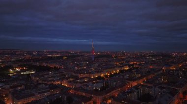 Alacakaranlıkta gökyüzünde hareket eden bulutlarla Prag şehrinin hava manzarası. Zizkov Televizyon Kulesi şehrin ufuk çizgisinde duruyor.