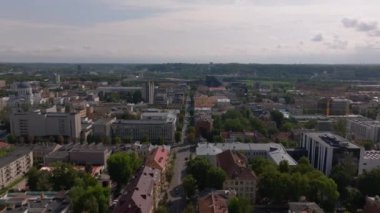 Gökyüzü altında yeşil alanlar, tarihi binalar ve modern mimari sergilenen Kaunas şehir manzarasını yukarıdan araştırıyoruz..