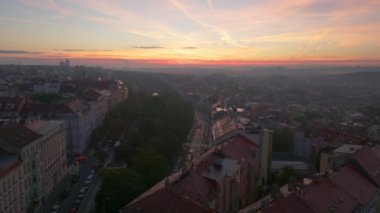 Hava görüntüleri Prag kentsel manzarasını gün batımında yakalıyor. Canlı Vinohradska Caddesi 'ni vurguluyor. Arabalar şehirde zikzak çizerken, güneş binaları ılık bir ışıltıyla yıkıyor..