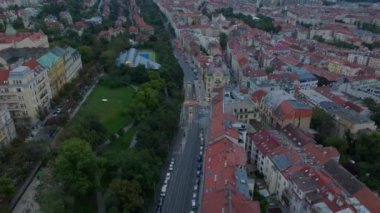 Prag 'da hava manzaralı bir cadde ve kavşağa doğru giden bir tramvay var. Kırmızı kiremitli çatılar ve bir park görülebilir.