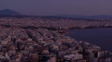 Yunanistan 'ın Selanik kenti üzerine alacakaranlık çökerken şehrin ışıkları parlıyor ve çarpıcı bir kent manzarası yaratıyor. Arka planda termaik körfez ışıldıyor, sahil kentleri cazibesini arttırıyor..