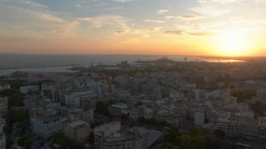 Yunanistan 'daki Selanik silueti üzerinde sersemletici bir günbatımı ışıltısı yansıtıyor. Termaik Körfez ve Liman, şehrin akşam cazibesini artırmak için pitoresk bir zemin oluşturur..