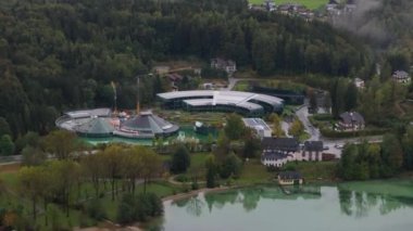 Avusturya 'da Fuschlsee kıyısında cam kubbeli yeni Red Bull karargahı inşa eden büyük bir inşaat vincinin havadan görüntüsü..