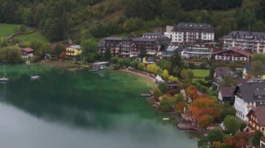 Fuschlsee kıyısındaki Fuschl am See, Avusturya 'daki otellerin havadan görüntüsü. Su koyu yeşildir ve ağaçlar sonbahar renklerini gösterir..