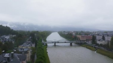 Yağmurlu bir sonbahar gününde Avusturya 'nın Salzburg kentindeki Salzach Nehri' nin üzerinden geçen arabalar, otobüsler ve kamyonlarla dolu bir köprünün hava görüntüsü..