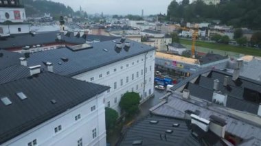 Avusturya, Salzburg 'un havadan görünüşü şehir merkezinde bir inşaat sahası olduğunu gösteriyor. Kamera çatıların üzerinde ilerliyor..