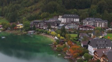 Avusturya 'daki güzel Fuschlsee' ye benzersiz bir açıdan yüksek açı, Fuschl am 'daki renkli sonbahar ağaçlarıyla çevrili lüks bir otel ve tatil köyünü gösteriyor..