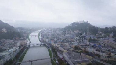 Avusturya 'nın Salzburg şehrinde kameralar görülüyor. Salzach Nehri şehir merkezi boyunca akar ve arka planda Hohensalzburg Kalesi bulunur..