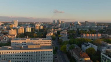 Altın saat boyunca Bratislava silueti üzerinde kamera görüntüsü. Modern binalar ve yemyeşil alanlar batan güneşin sıcacık ışığında yıkanır..