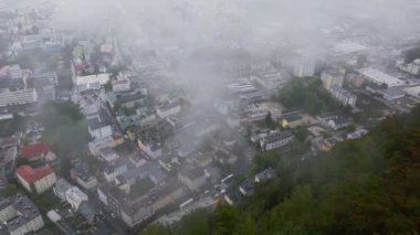 Alçak bulutlar yavaşça Salzburg, Avusturya 'ya doğru hareket ediyor. Sis çöktüğünde binalar ve sokaklar görülebilir..