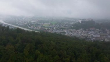 Avusturya, Salzburg 'da bulutlar toplanıyor. Salzach Nehri şehrin içinden akıyor. Hohensalzburg Kalesi bir tepede duruyor..