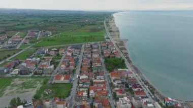 Ege Denizi boyunca canlı bir turistik bölge olan Paralia Katerinis 'i gösteren hava manzarası. Kamera kumsalda, otellerde ve manzaralı bir çevrede süzülüyor..