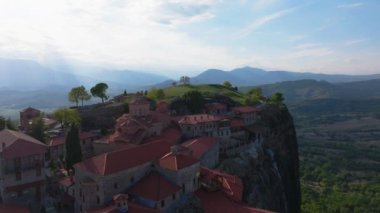 Gökyüzü manzaraları, Yunanistan 'daki yemyeşil ve görkemli dağlarla çevrili, yüksek kaya oluşumlarına tünemiş çarpıcı Meteora manastırlarını gösteriyor..