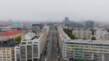 Bulutlu bir günde, Brno şehir merkezinde geniş bir cadde boyunca arabalar ve kamyonlar hareket ediyor. Apartman binaları, otopark ve iş yerleri caddeleri kaplıyor..