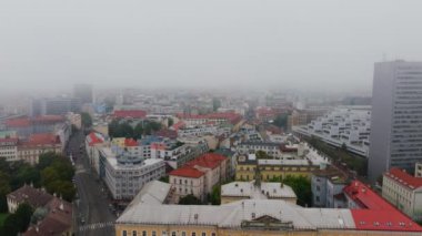 Çek Cumhuriyeti 'nin Brno kentinin hava perspektifi, modern ve geleneksel mimarinin bir karışımını sergileyen bir sis tabakasıyla kaplı..