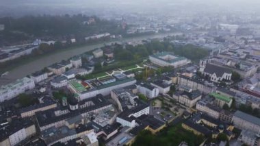 Avusturya, Salzburg 'un havadan görünüşü. Şehir merkezinde sisli bir günde binaları ve Salzach Nehri 'ni gösteren bir kamera var..