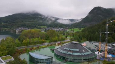 Avusturya, Salzburg yakınlarındaki Fuschlsee sahilinde Red Bull Karargahı 'nı inşa eden inşaat işçileri. Hava manzarası Avusturya Alpleri 'nin çarpıcı manzarasını gözler önüne seriyor..