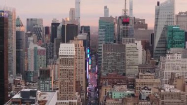 Günbatımında Times Meydanı 'nın canlı görüntülerini gösteren kamera görüntüleri, yüksek gökdelenlerle çevrili yoğun caddelerde turistleri ve işçileri vurguluyor..