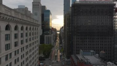 New York şehrinin gökdelen camlarında gün ışığı parıldıyor. Arabalar aşağıdaki canlı caddelerde yol alırken, şehir yaşamının dinamik ruhunu gün doğumunda sergiliyorlar..