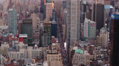 Hava görüntüleri Manhattan şehir merkezini gün batımında canlı bir siluet, işlek sokaklar ve akan trafiği görüntülüyor. Aydınlatılmış gökdelenler çarpıcı şehir manzarasını geliştirir..