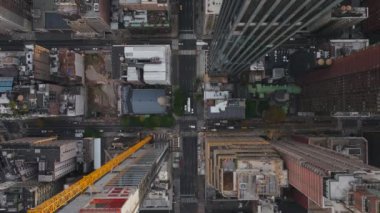 Havadan bakıldığında, canlı bir New York caddesi üzerinde dönen bir inşaat vincinin canlı şehir manzarasını ve metropolde devam eden gelişmeleri vurguluyor..