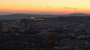 Slovakya 'nın başkenti Bratislava, güneş ufukta batarken yavaşça parlıyor, şehir ve kale boyunca sıcak, altın bir parıltı saçıyor..