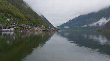 Gölün kıyısına kurulmuş ve dağlarla çevrili olan Hallstatt köyü yamaçlardan aşağı doğru yavaşça sisle kaplanıyor..