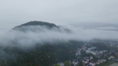 Salzach Nehri ve Avusturya 'nın Salzburg kenti ile Kapuzinerberg dağı üzerinde hareket eden alçak asılı bulutların hava manzarası.