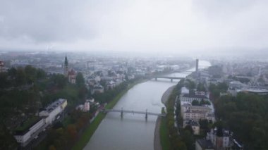Kasvetli bir günde şehrin üzerinde sürüklenen bulutlar, Salzkammergut nehrinin Salzburg, Avusturya 'yı kaplayarak kentsel manzarayı ve tarihi mimariyi vurguluyor..