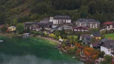 Avusturya 'nın Fuschlsee kentindeki göl manzaralı bir tatil beldesi, canlı sonbahar yeşillikleriyle kaplıdır. Renkli ağaçlar sakin ve resimli bir alp manzarası oluşturur..