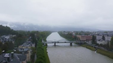 Yağmurlu bir sonbahar gününde Avusturya 'nın Salzburg kentindeki Salzach Nehri' nin üzerinden geçen arabalar, otobüsler ve kamyonlarla dolu bir köprünün hava görüntüsü..