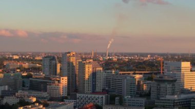 Bratislava, Slovakya 'daki bir bacadan yükselen duman, sıcak günbatımı renkleriyle yıkanan ve alacakaranlıkta çarpıcı bir şehir manzarası yaratan şehrin silueti ile çelişiyor..
