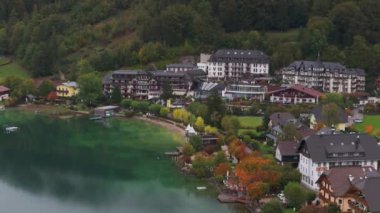 Avusturya 'daki güzel Fuschlsee' ye benzersiz bir açıdan yüksek açı, Fuschl am 'daki renkli sonbahar ağaçlarıyla çevrili lüks bir otel ve tatil köyünü gösteriyor..