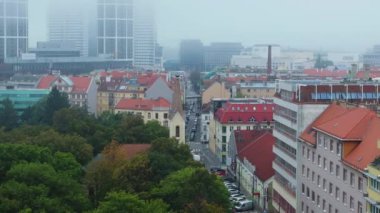 Havadan bakıldığında Brno, Çek Cumhuriyeti, canlı kırmızı çatılar ve verimli yeşillikler sergilenirken, modern AZ Kulesi açık mavi gökyüzüne karşı dik duruyor..