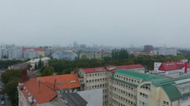 Çek Cumhuriyeti 'nin Brno kentindeki ikonik kırmızı çatılar ve yemyeşil alanlar hava manzaralarıyla ön plana çıkıyor. Ufuk çizgisi bulutlu bir gökyüzü altında modern ve tarihi mimariyi harmanlıyor..