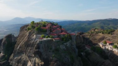 Havadan bakıldığında, Büyük Meteoron 'un Kutsal Manastırı, Kurtarıcının Dönüşümü, Bizans mimarisinin etkileyici bir örneği, Yunanistan' ın Meteora kentindeki dik bir kaya oluşumuna tünemiş..