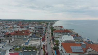 Turistler, bulutlu bir yaz gününde Paralia Katerinis sahilinde yürürken Ege Denizi 'nde Yunan tatilinin tadını çıkarıyorlar..