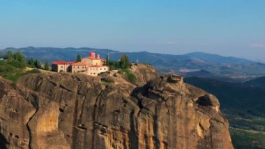 Kamera, Büyük Meteoron 'un Kutsal Manastırı' nı, Yunanistan 'daki Meteora' daki bir kaya oluşumunun üzerindeki Kurtarıcının Dönüşümü 'nü gösteriyor. Bölgeyi turistler ziyaret ediyor.