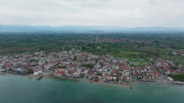 Paralia Katerinis 'in üzerinde süzülen büyüleyici bir hava manzarası, Ege Denizi' nin canlı mavi sularıyla harmanlanmış pitoresk şehir manzarasını gözler önüne seriyor..