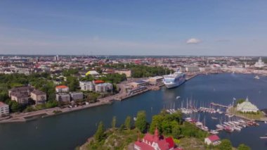 Helsinki, Finlandiya 'da, limanında sıcak güneş ışığıyla yıkanmış bir şehir manzarası tarafından gözden kaçırılan feribot ve yatlarla dolu bir liman bulunmaktadır..