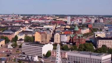 Helsinki 'nin büyüleyici manzarası Uspenski Katedrali ve dönme dolabı ön plana çıkarıyor. Kamera şehrin üzerinde pürüzsüz bir şekilde süzülüyor, çarpıcı mimarisini ve canlı atmosferini gösteriyor..