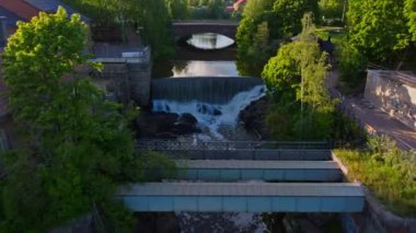 Helsinki 'den akan bir nehrin havadan görüntüsü. Yeşiller yemyeşil ağaçlar ve köprüler görülebilir, resimli bir şelale ile birlikte..
