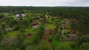 Yeşillik ve kayalık arazilerle çevrili, kırmızı ahşap evleri olan büyüleyici bir köyün havadan görünüşü, Finlandiya 'nın Aland kentinin huzurlu kırsalını gözler önüne seriyor..