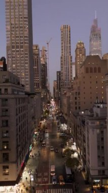 Beşinci Cadde, Manhattan, New York City 'deki trafiğin dikey görüntüsü. Arabalar ve taksiler arka planda şehir silüeti olan caddeden aşağı iniyor..