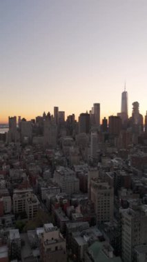 Manhattan 'ın Finansal Bölgesi' ndeki kameralar, New York 'un Aşağı Doğu Yakası' nı altın saat boyunca görüntülüyor ve şehrin ikonik ufuk çizgisini dikey bir videoda gösteriyor..