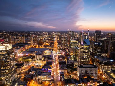 Nashvilles stunning cityscape shines during a gorgeous sunset, highlighting the iconic ATandT building, Batman building, and Broadway Street with vibrant entertainment scene. clipart