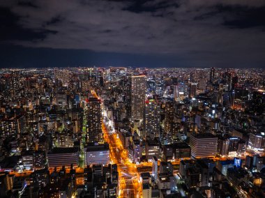 Geceleri yüksek binalar ve aydınlık caddelerle Osaka 'lar Japonya' da çarpıcı bir gece göğü altında çarpıcı bir şehir manzarası yaratıyor..